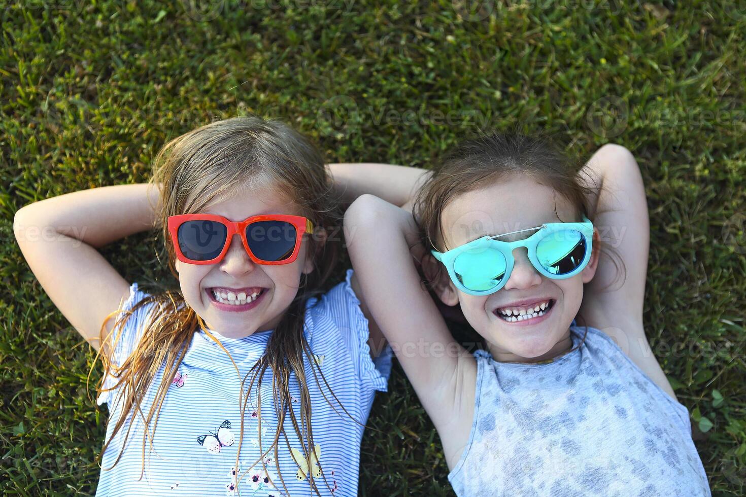 Laughing children wearing sunglasses relaxing during summer day photo