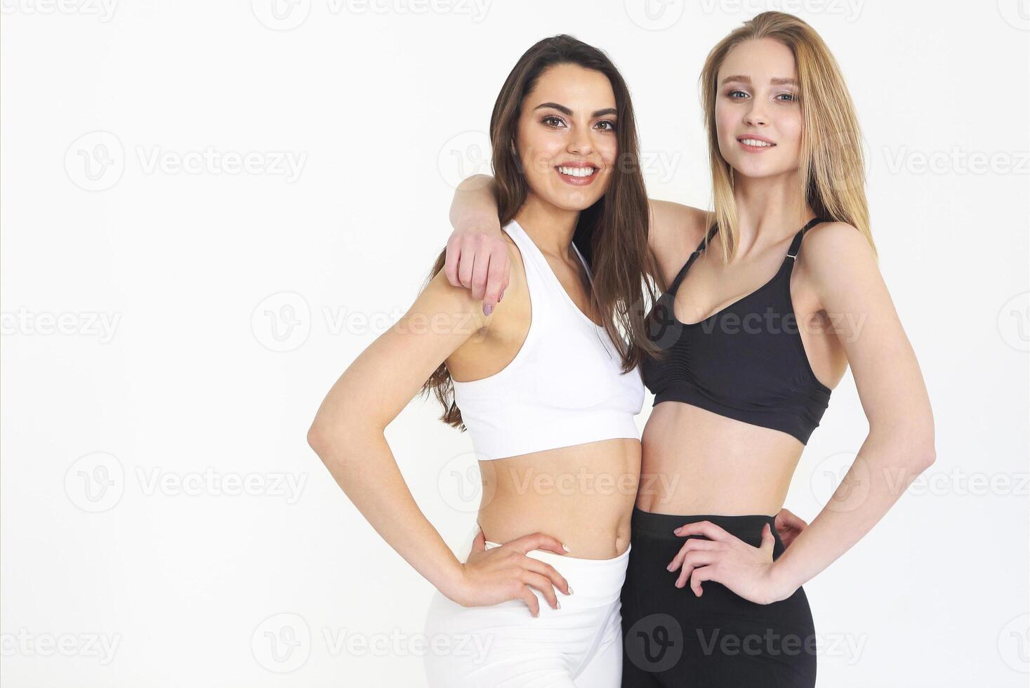 Two sport girls blond in black and brunette in white isolated on white photo