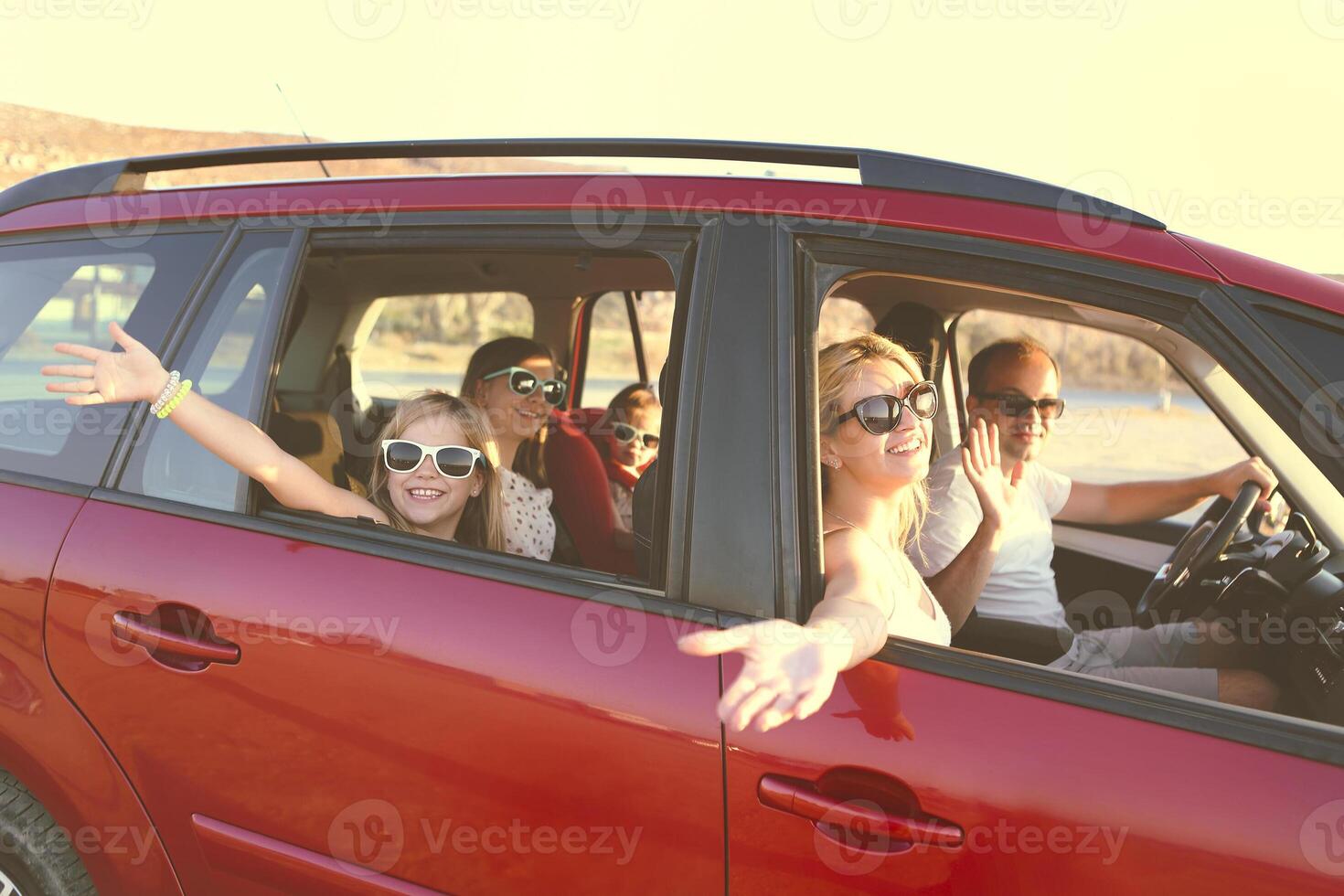 Happy smiling family with daughters in the car with sea background photo
