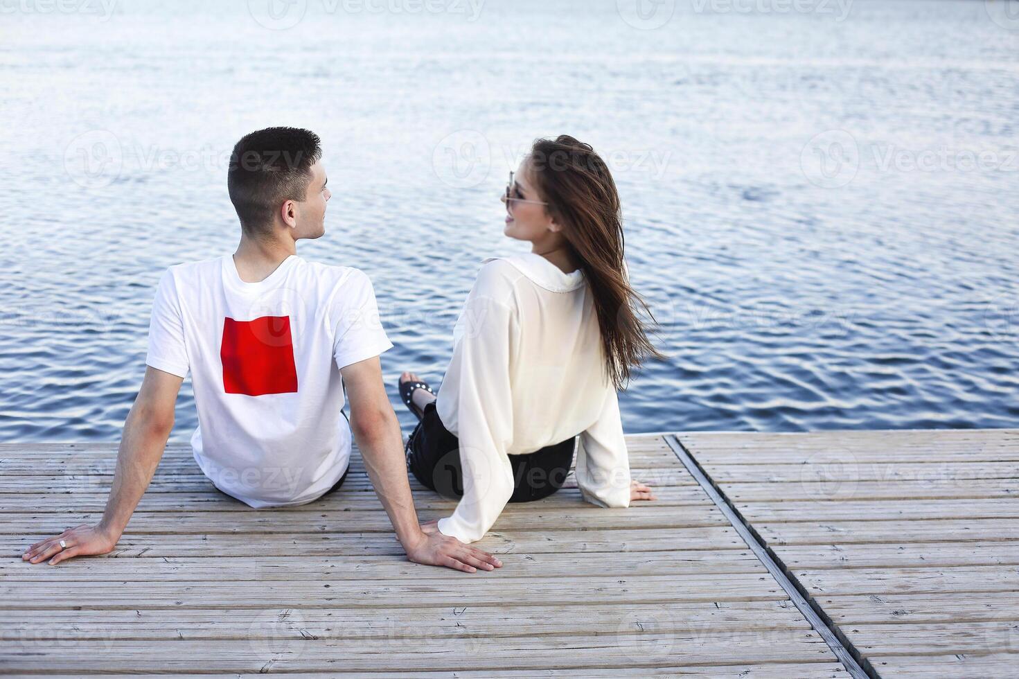 Young couple relaxing on pier in summer photo