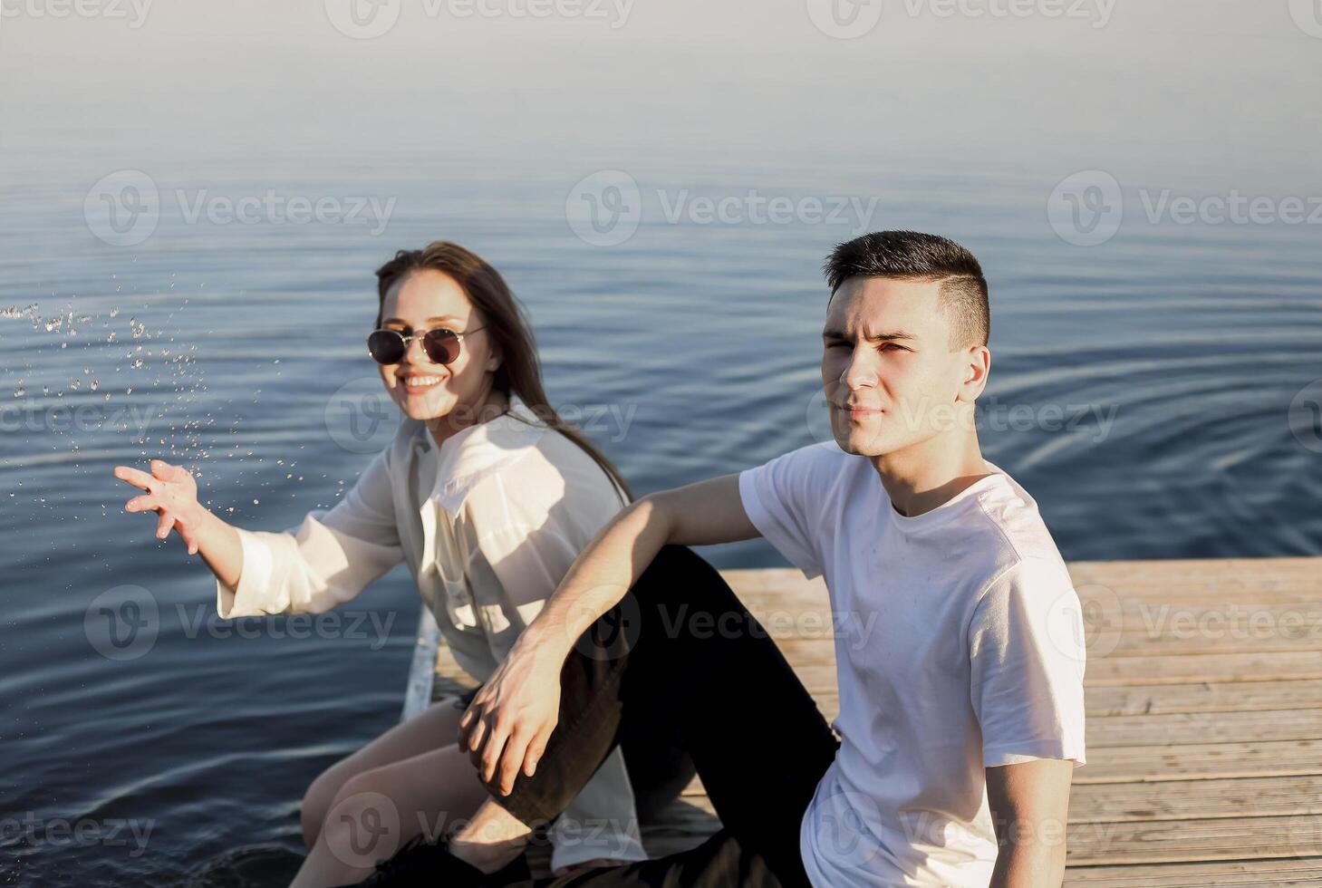 Young couple relaxing on pier in summer photo