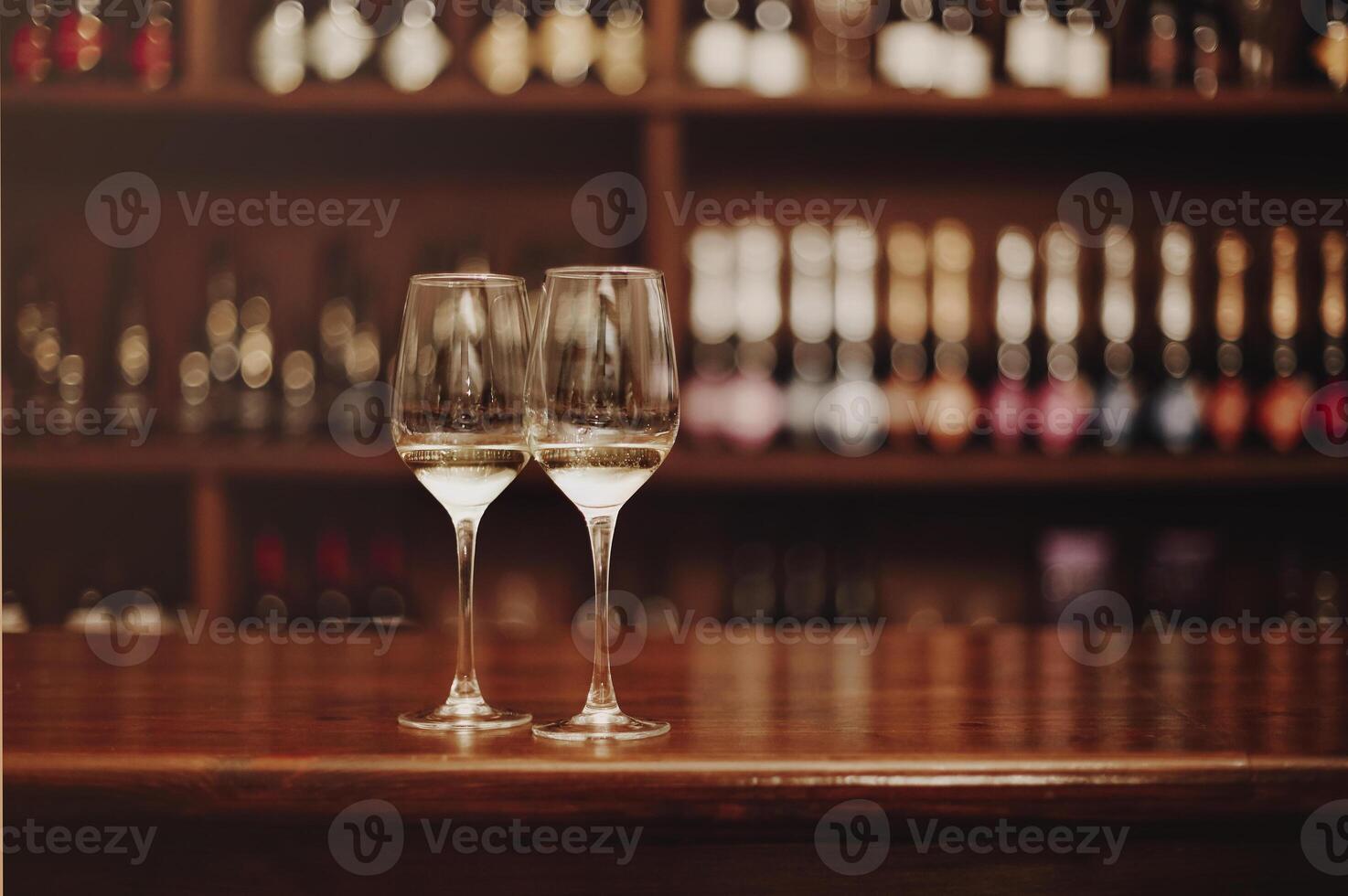 Two glasses of white wine on the wooden bar table photo