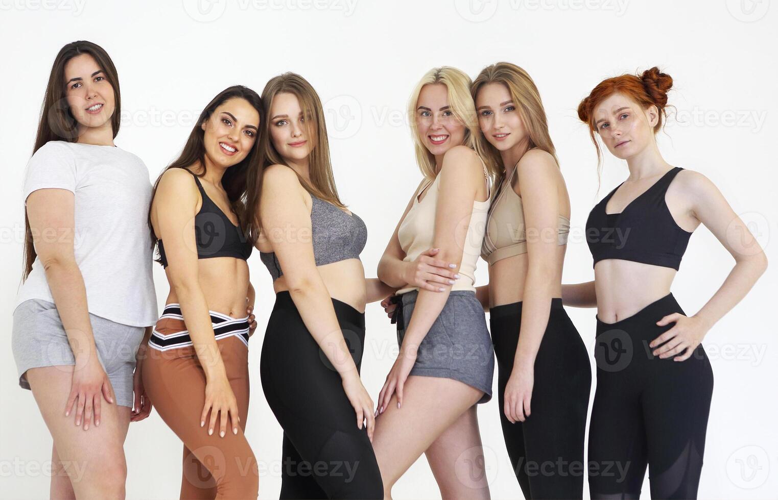 Happy different race women wearing sports top and leggings photo