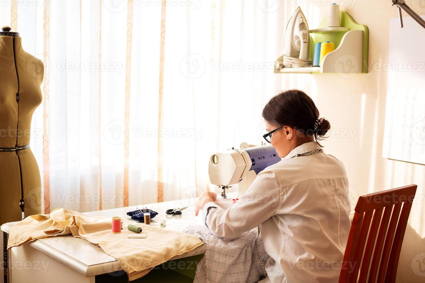 Female dressmaker creating clothes in workshop photo