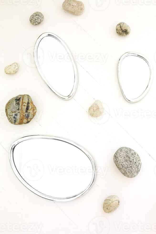 Mirrors and stones on white background photo