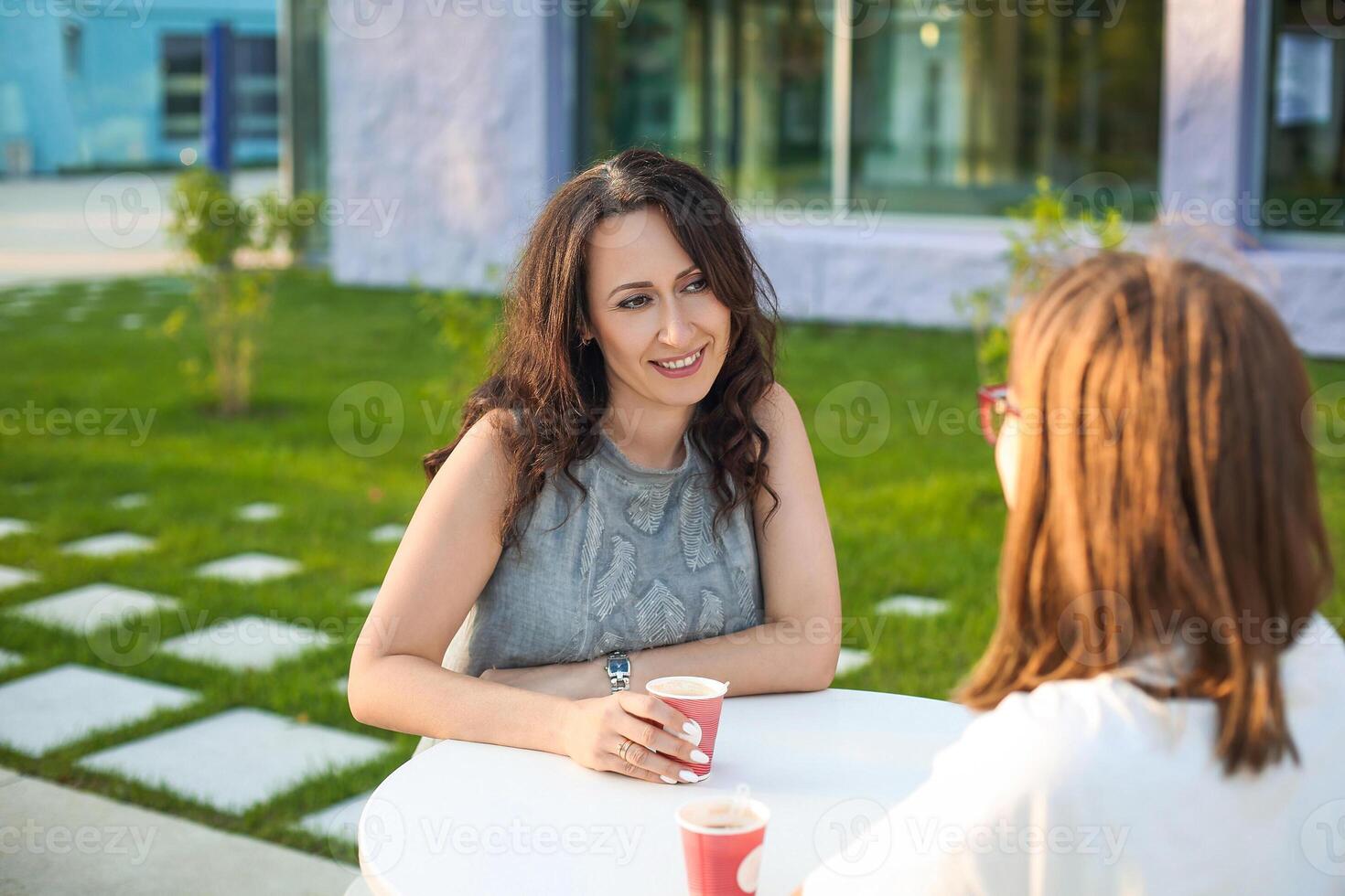 Mother and daughter drinking coffee in evening photo