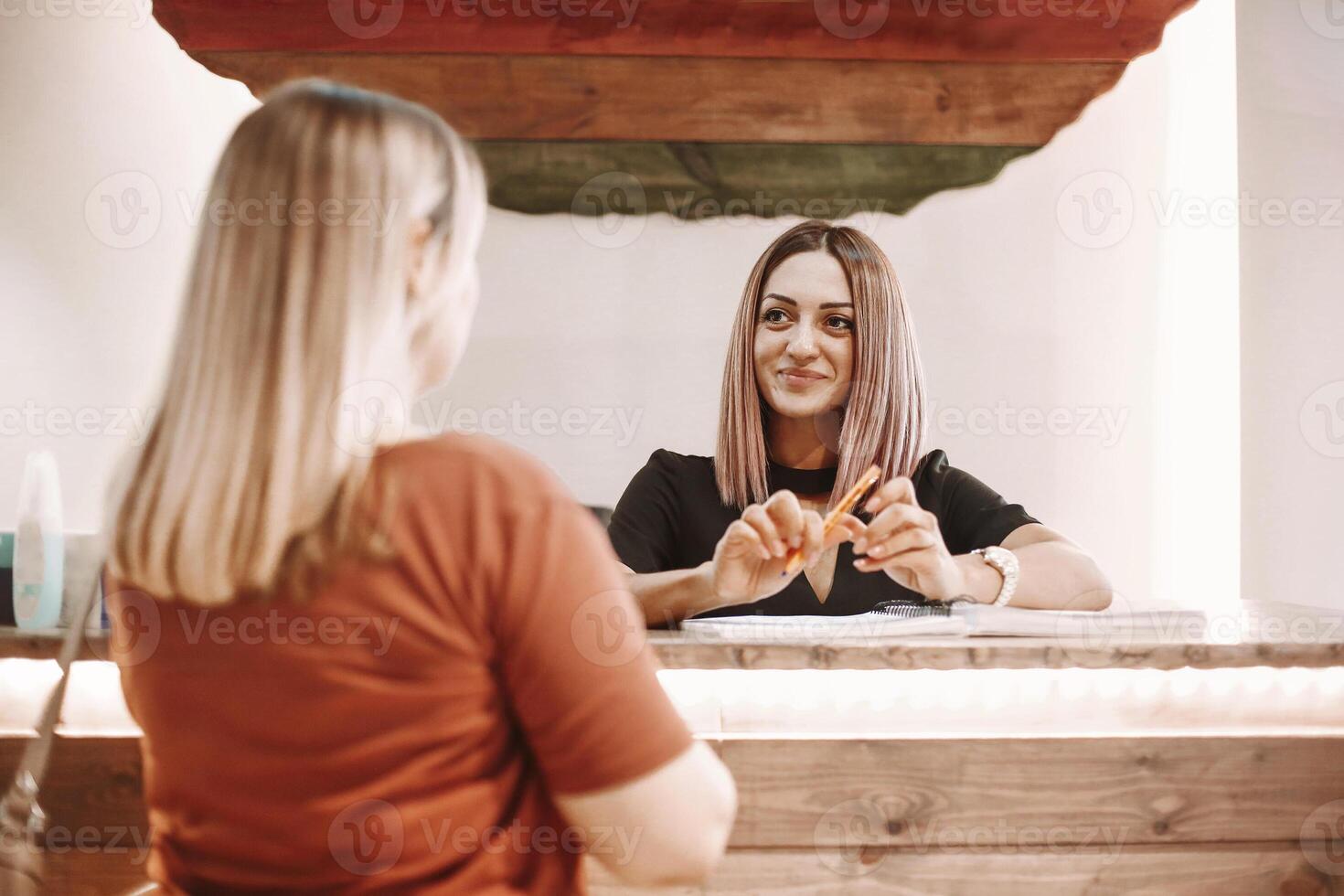 Woman writing appointment of client in salon photo