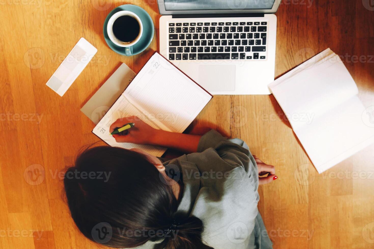 Unrecognizable freelancer making notes and working on floor photo