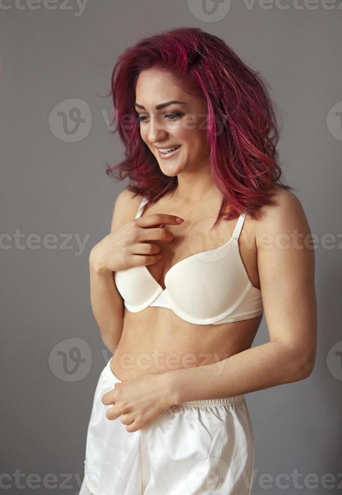 Beautiful young smiling woman with bright hair in white lingerie photo