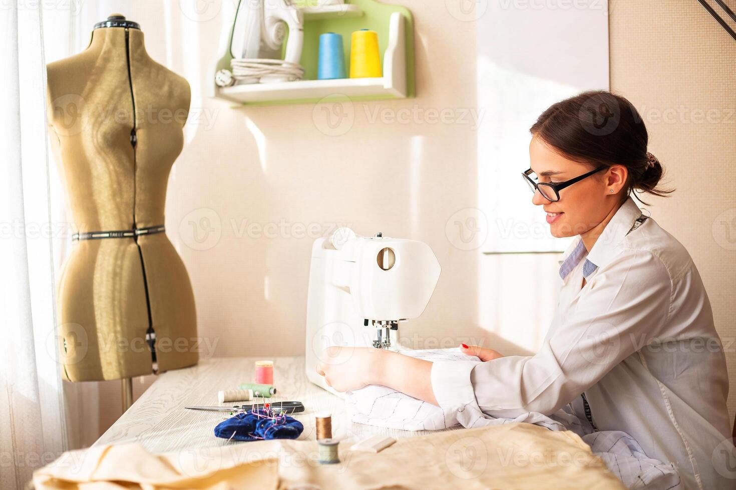 Female dressmaker creating clothes in workshop photo