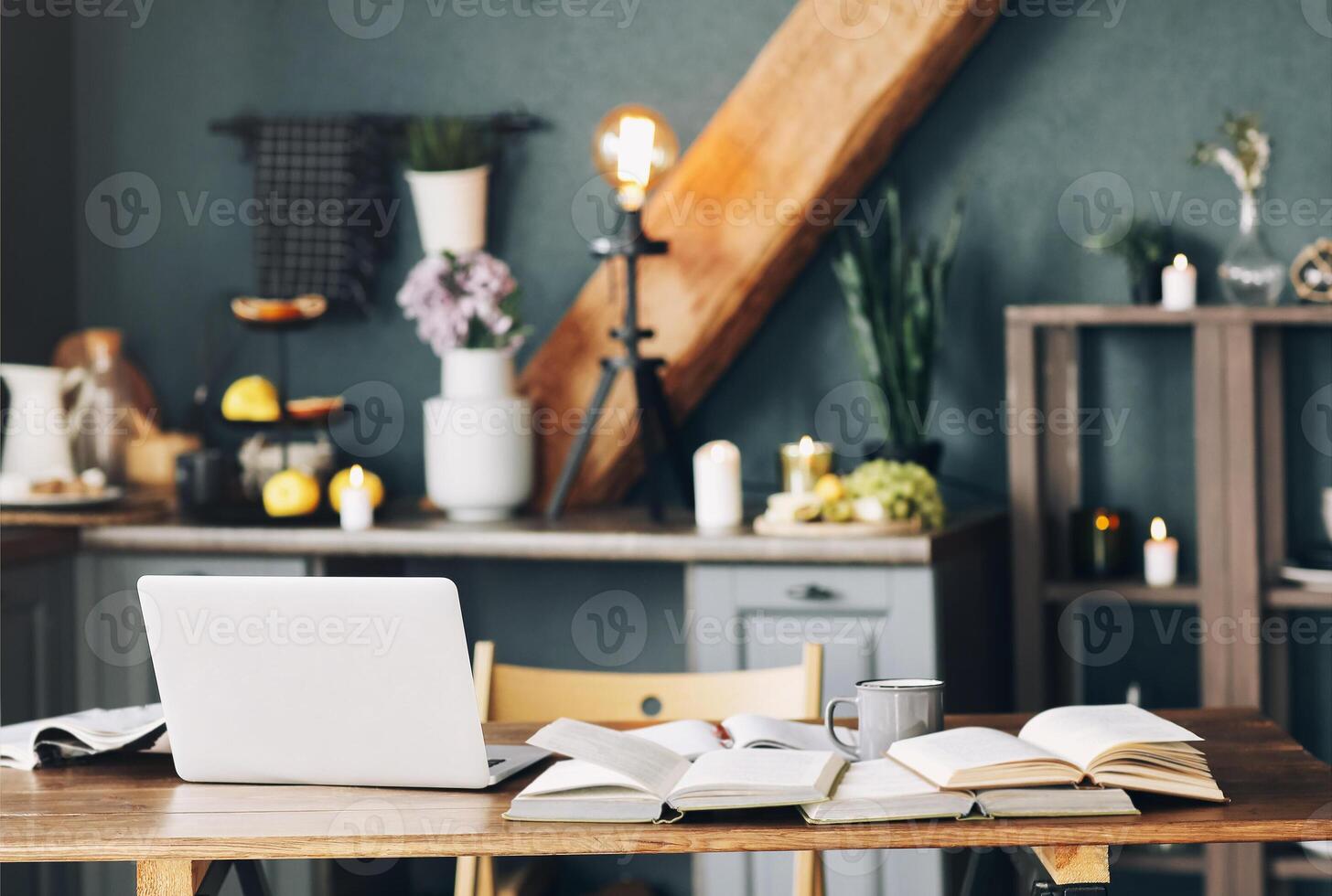 Open textbook with pen, laptop, stack of uncovered books and cup of coffee on table at home office photo