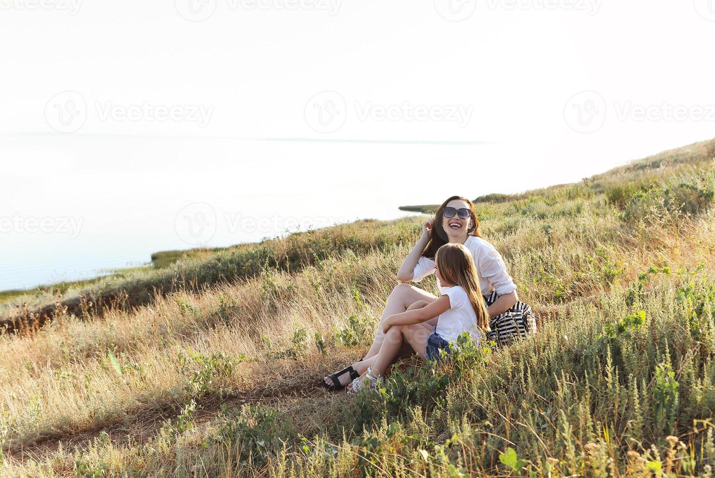 Happy woman and girl hugging in field photo
