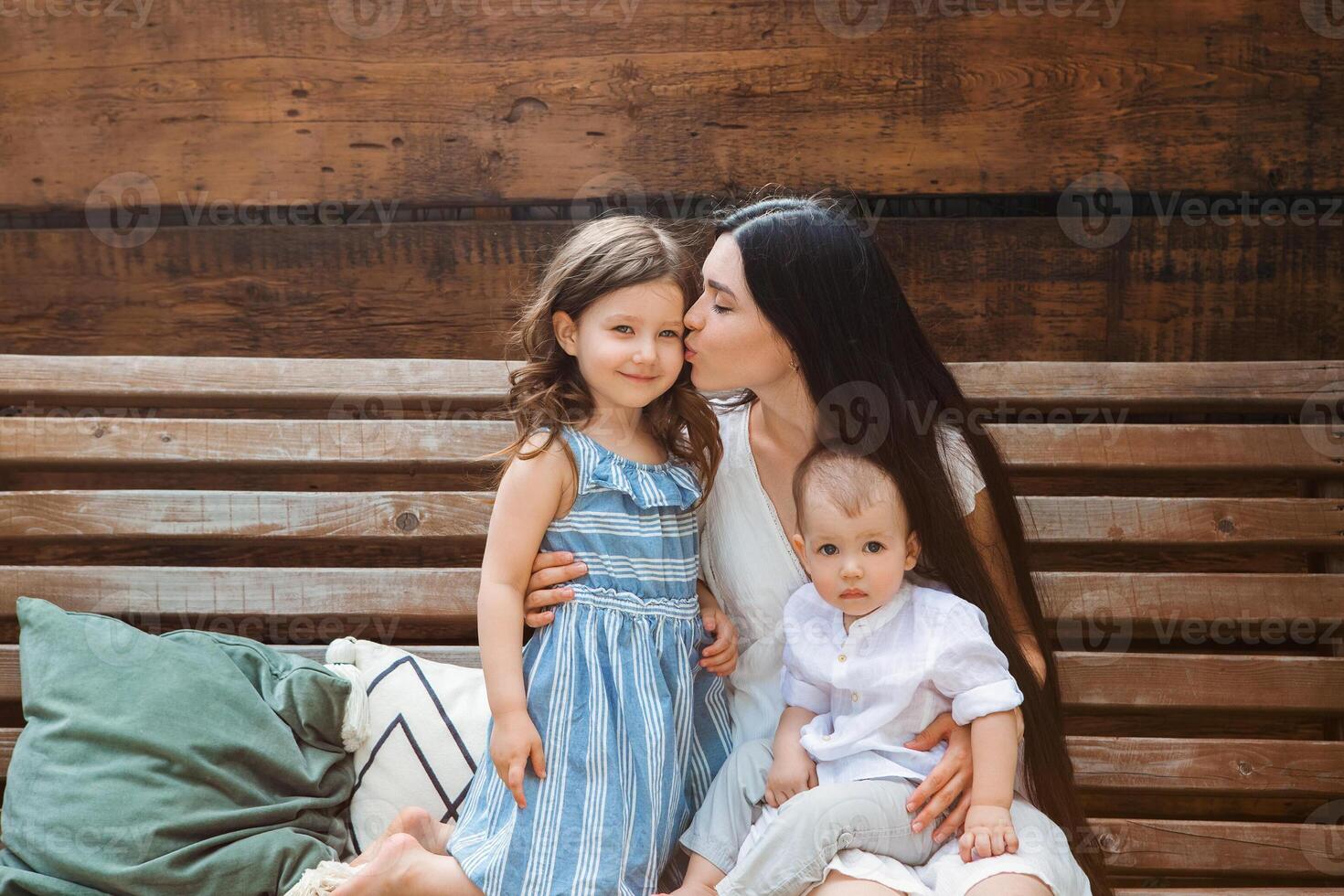 Smiling woman with cute kids on terrace photo