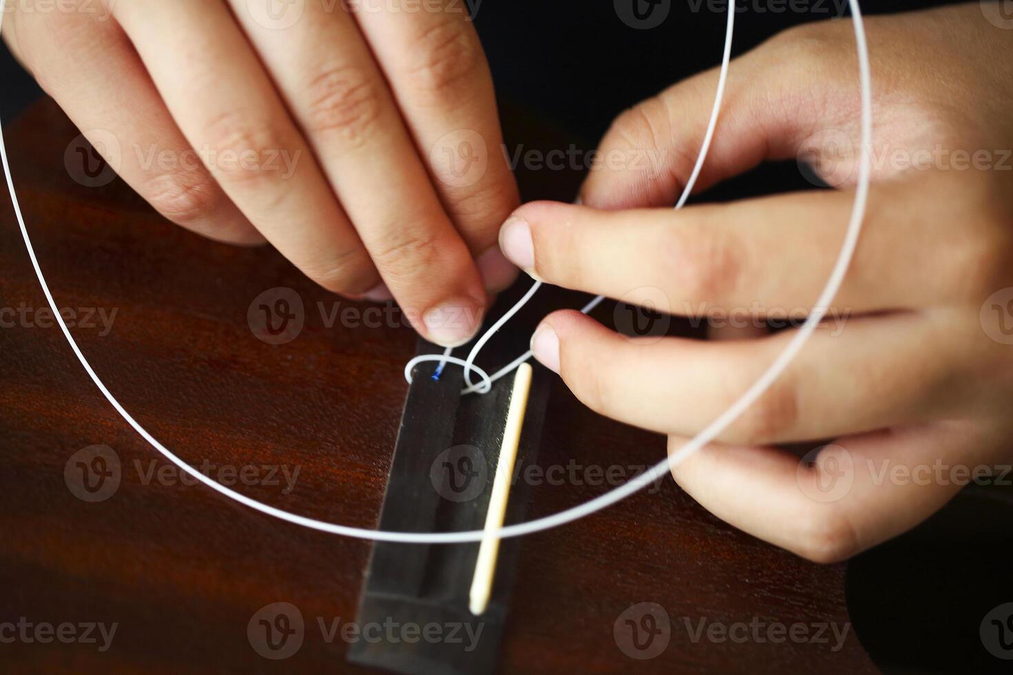 Tuning the string of ukulele, human hands photo