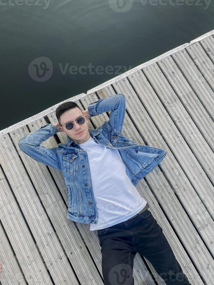 Calm man resting on wooden pier photo