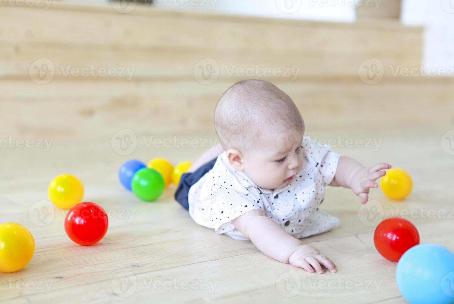 Baby boy playing with balls. Kid in play room. Toddler kid with balls for children. photo