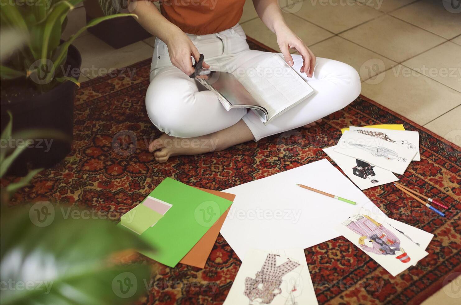 Young female creating her Feng Shui wish mapsitting on the carpet in the room in boho style photo