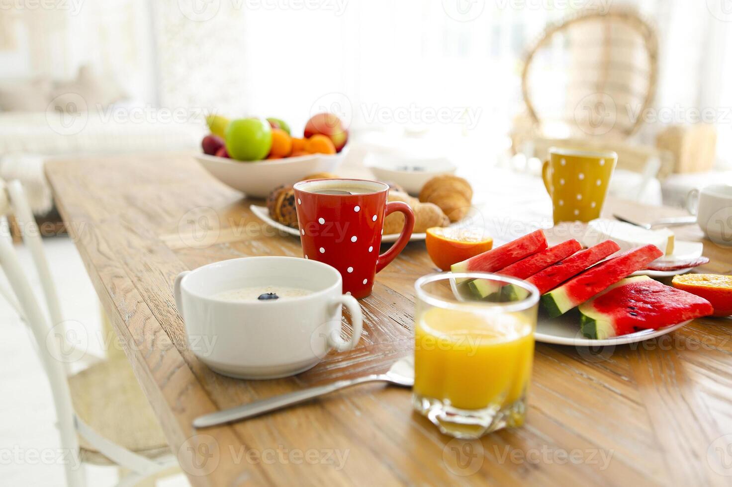 Coffee with fruit, cereal and croissant on wooden table background photo