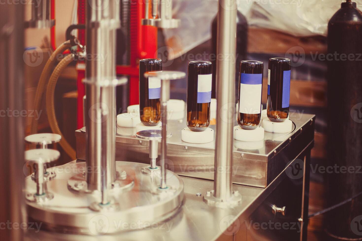 Wine bottles ready to be filled with wine by an industrial machine in a winery photo