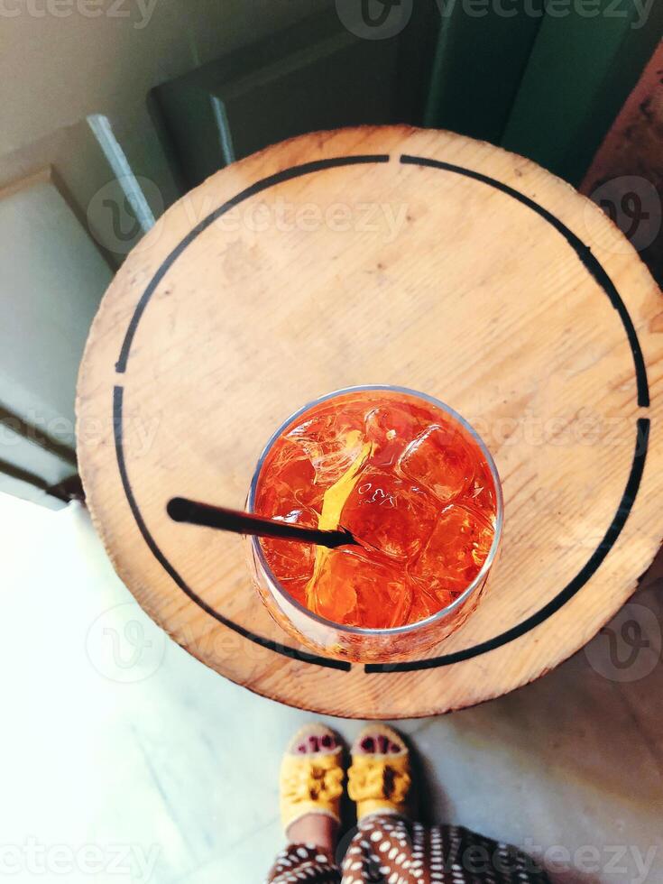 Anonymous female and goblet of alcohol cocktail with cherries and black straw photo