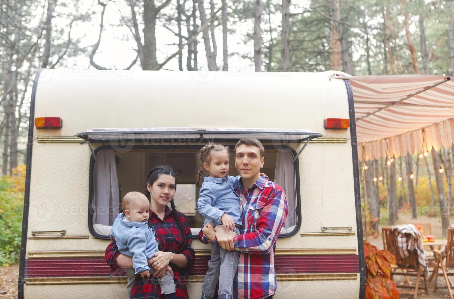Portrait of the smiling happy family with kids in the house on wheels photo