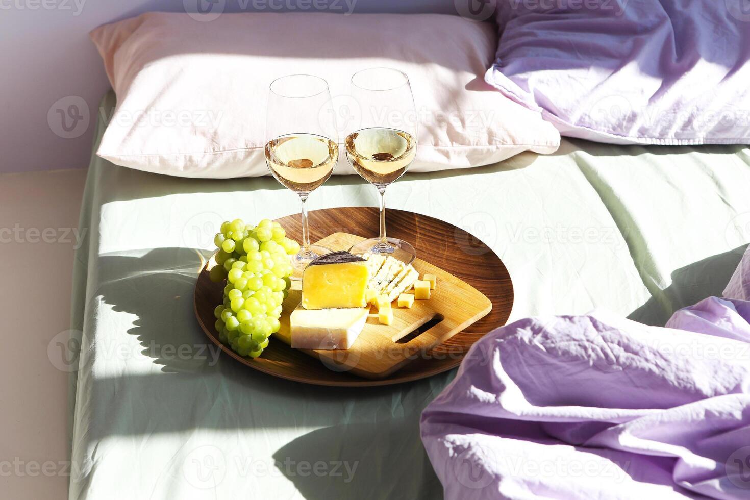 Wine and food on bed in sunny day photo