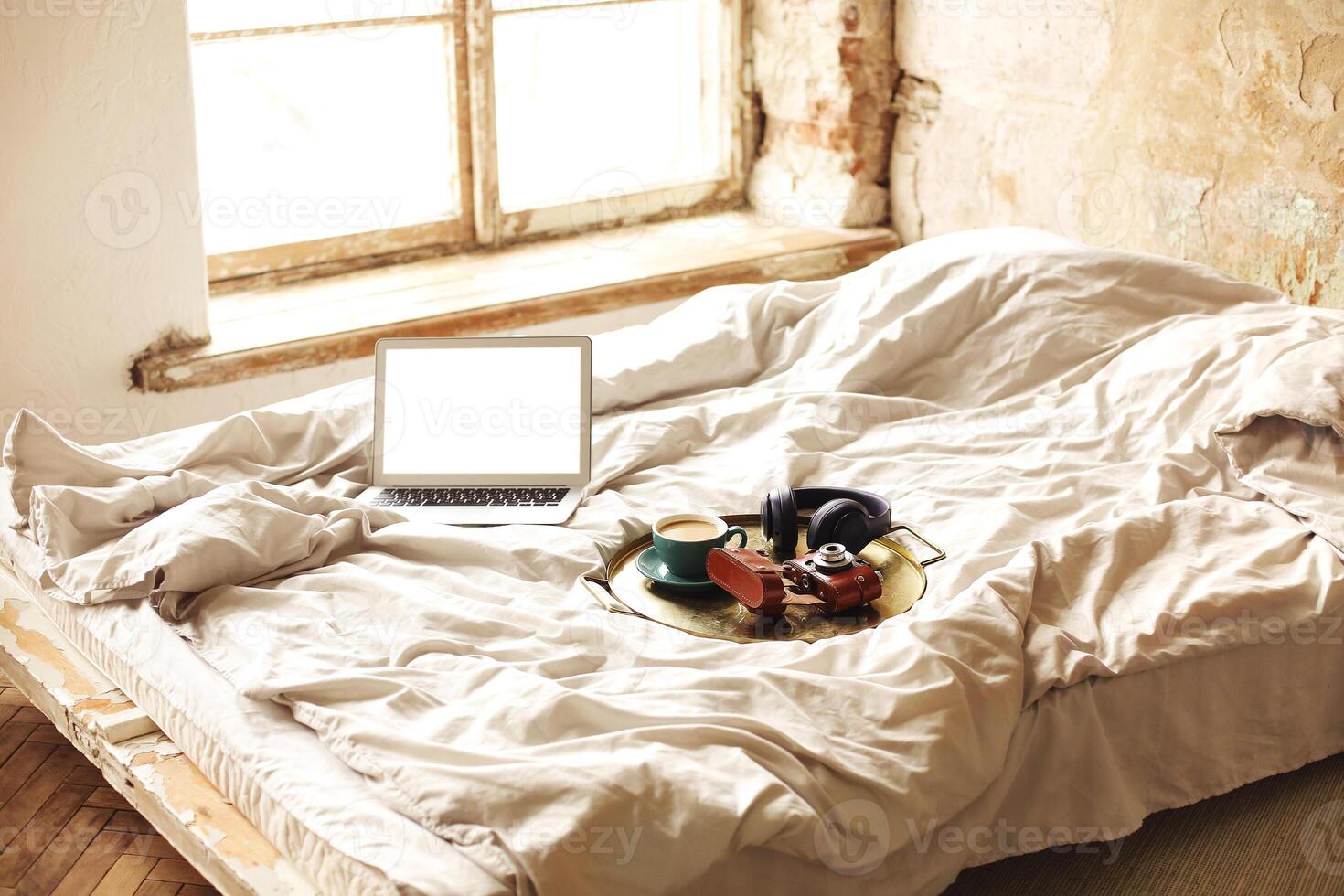 Work from home, the rays of the morning sun, and random things scattered on the bed photo
