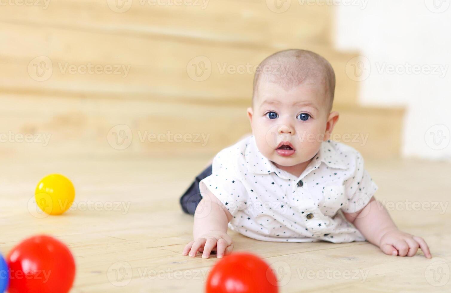Baby boy playing with balls. Kid in play room. Toddler kid with balls for children. photo