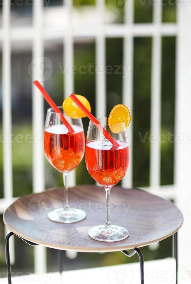Two orange cocktails with straw on wooden table photo