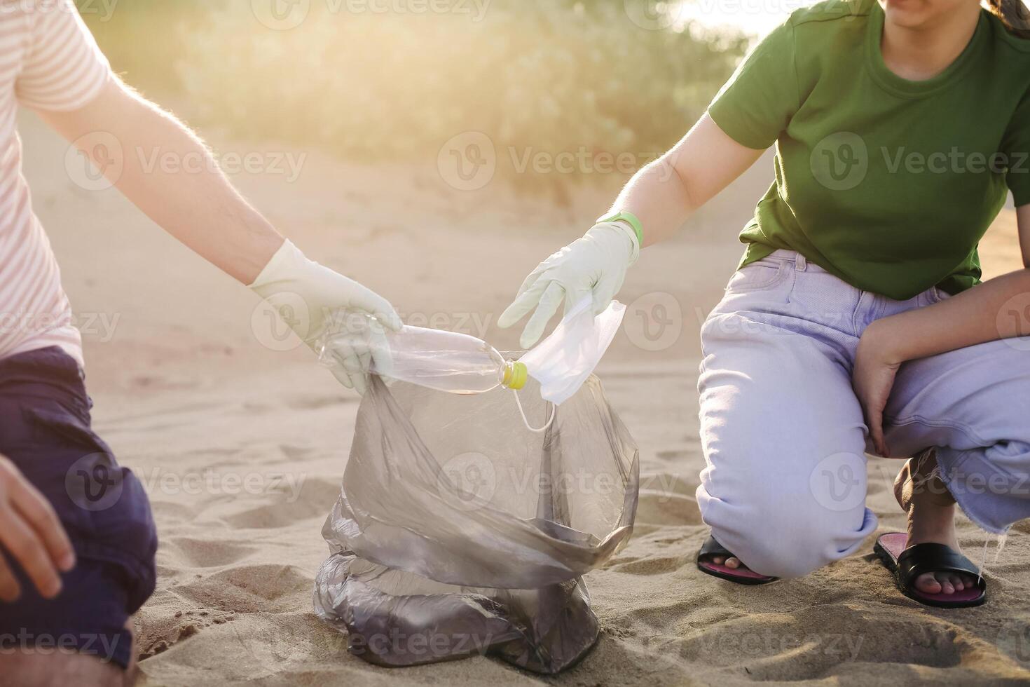 Volunteers collect trash, plastic garbage bottles on the beach. Ecology, environment, pollution and ecological problems concept photo