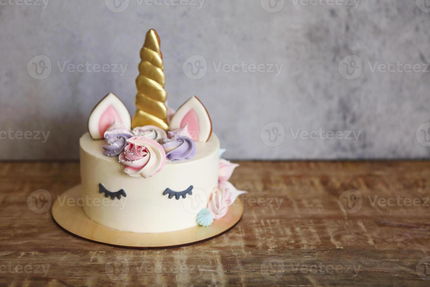 Beautiful bright cake in the form of a unicorn with cream colored flowers photo