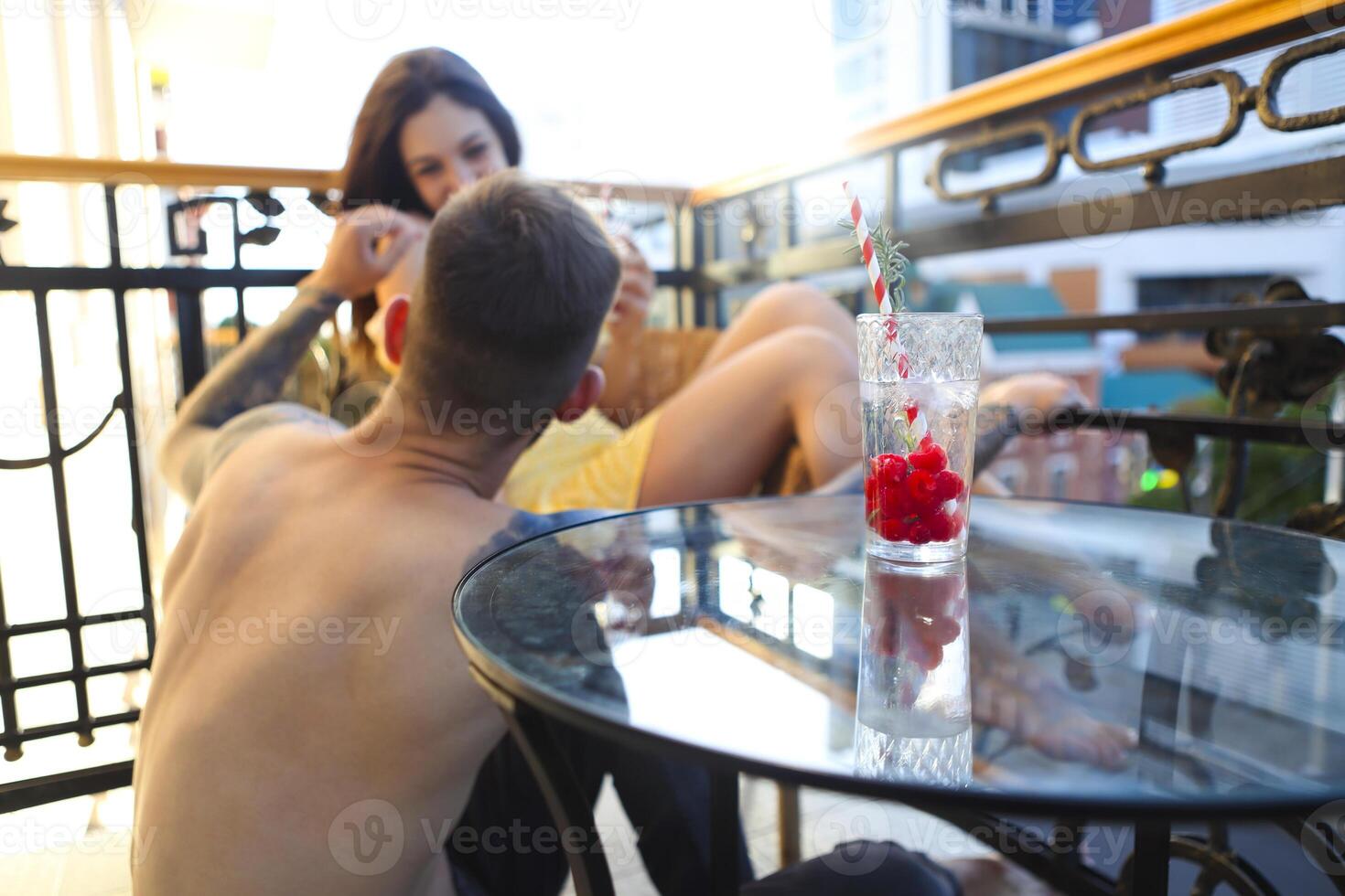 Couple in love drinking summer refreshing lemonade with rasberry on a balcony photo