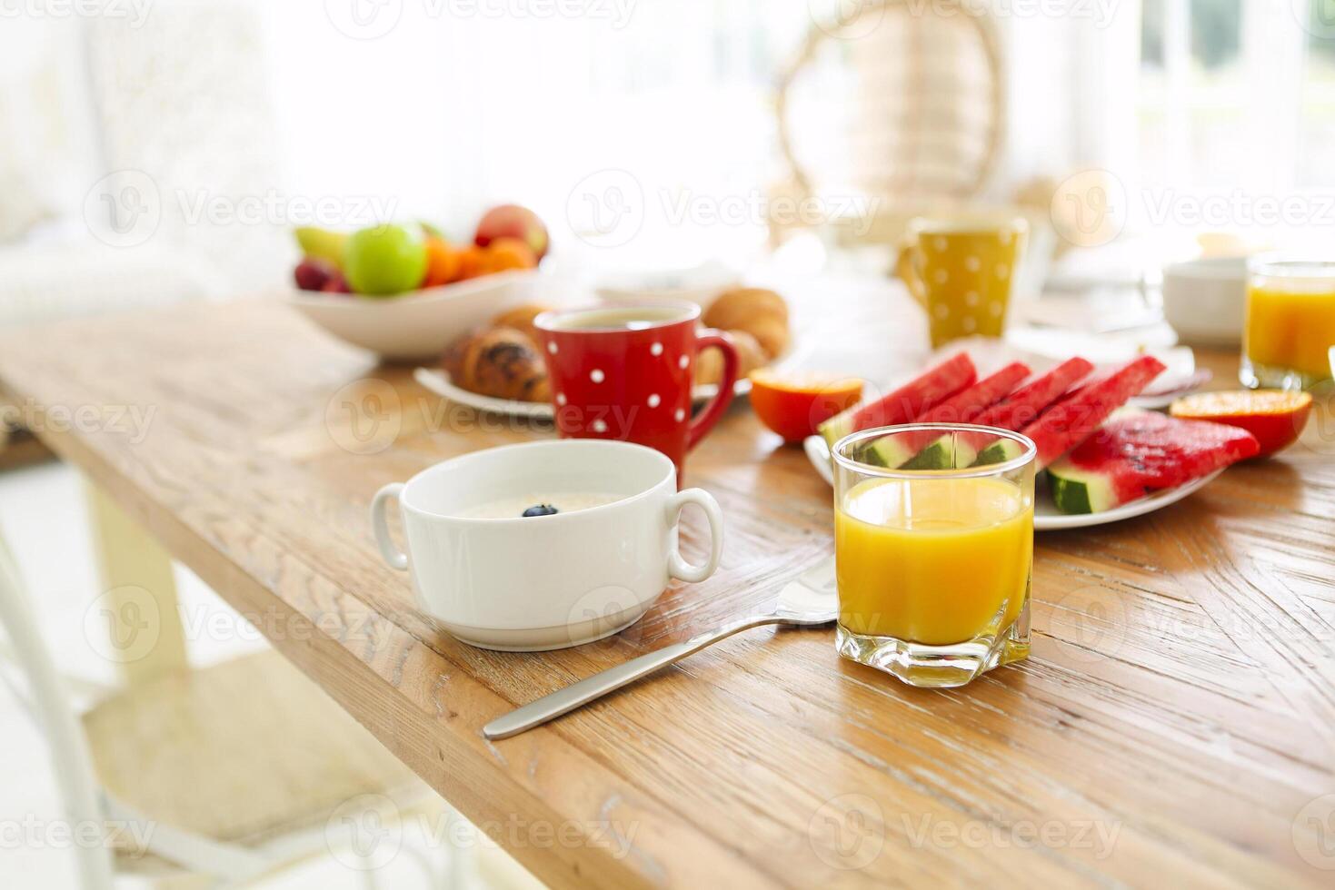 Coffee with fruit, cereal and croissant on wooden table background photo
