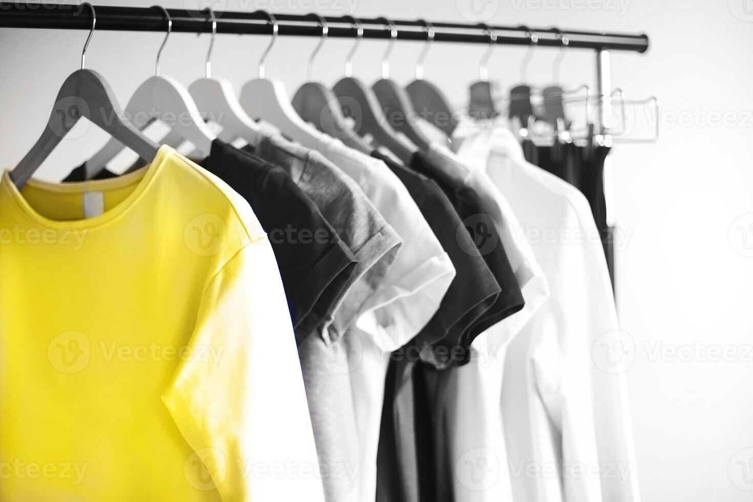 Colorful clothes hanging on rack in room photo