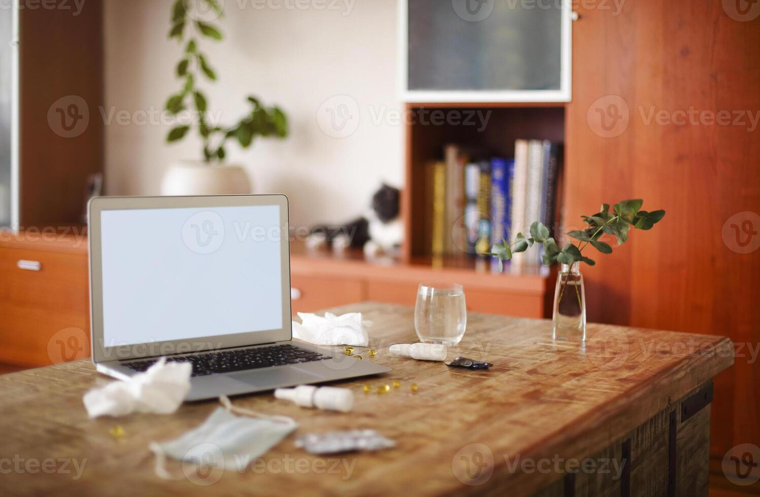 Medications on table near laptop photo