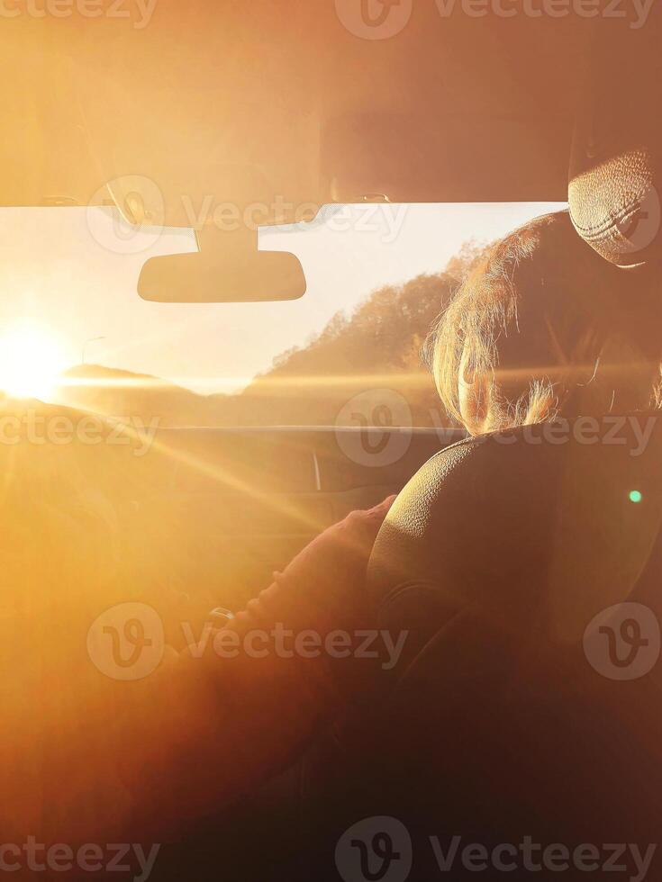 Woman in car during sunset photo
