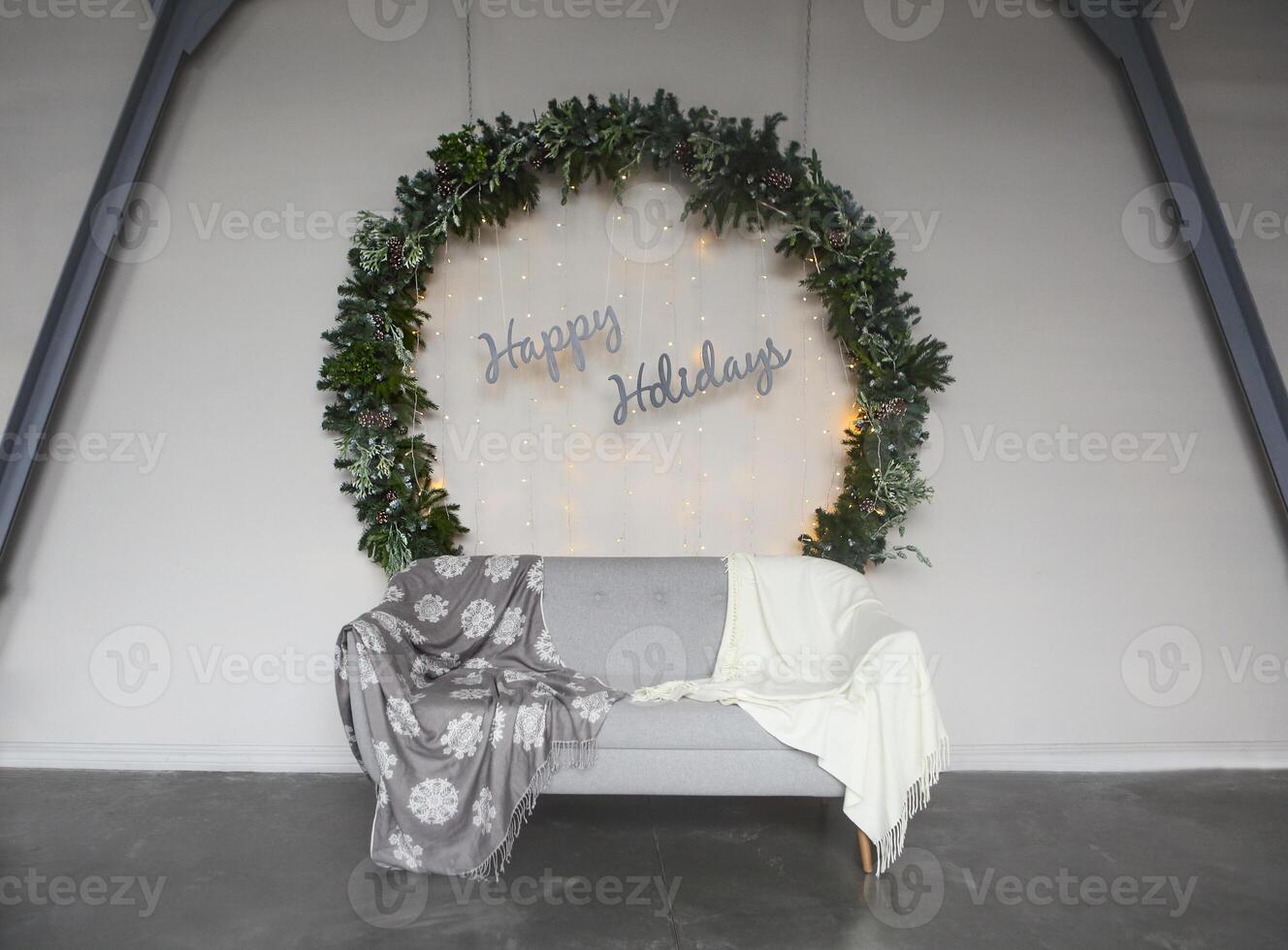 Big Christmas wreath by the wall with sign Happy Holidays photo