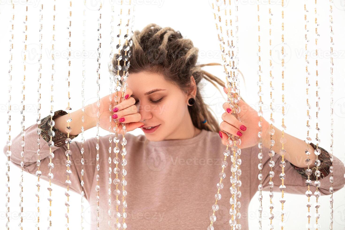 Happy woman shaking dreadlocks and smiling photo