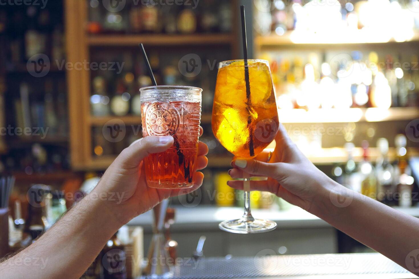 Woman and man raising a glasses of coktails in the bar photo