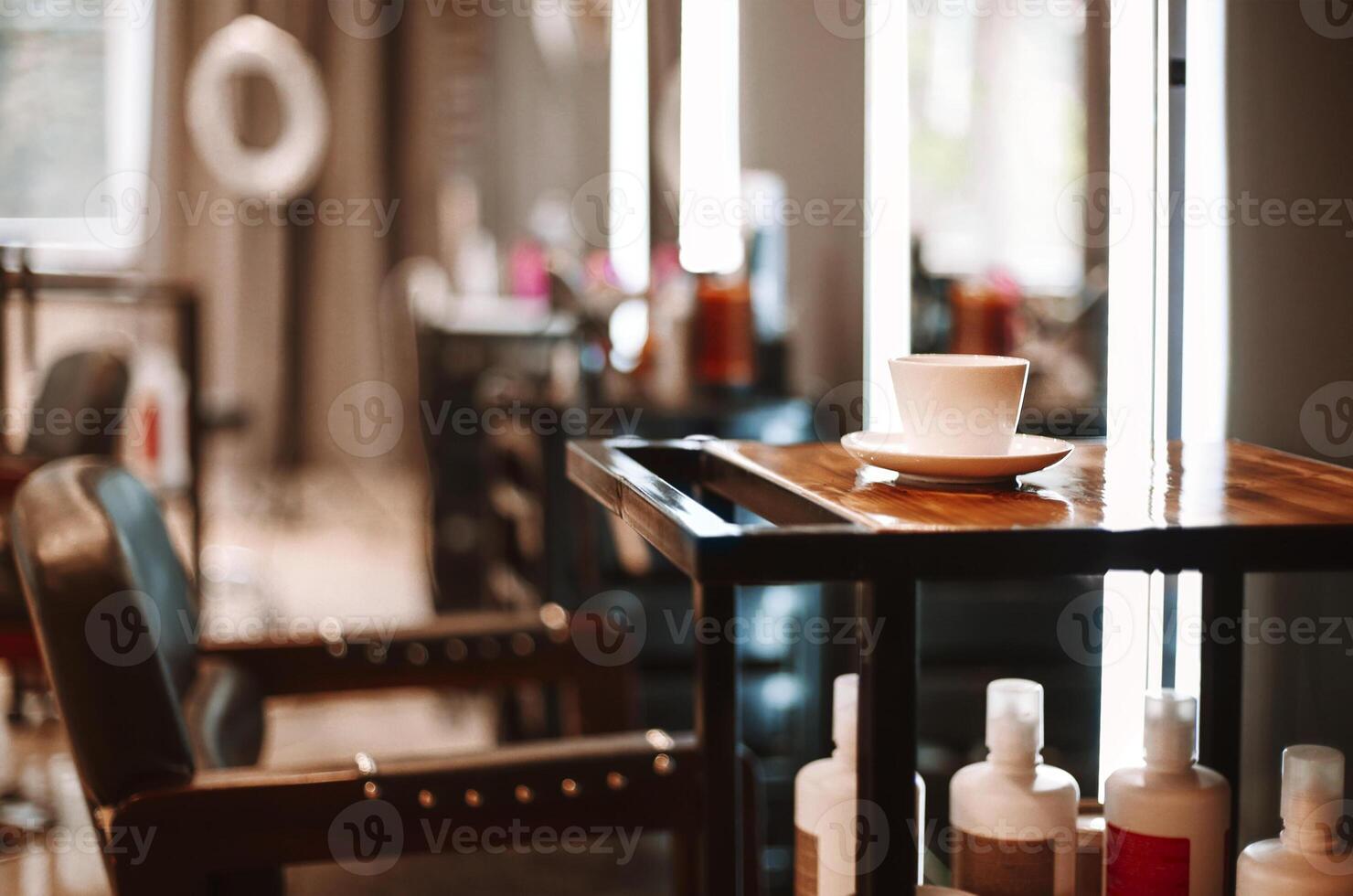 Coffee cup on wooden table and chair for client in empty hairdresser salon photo