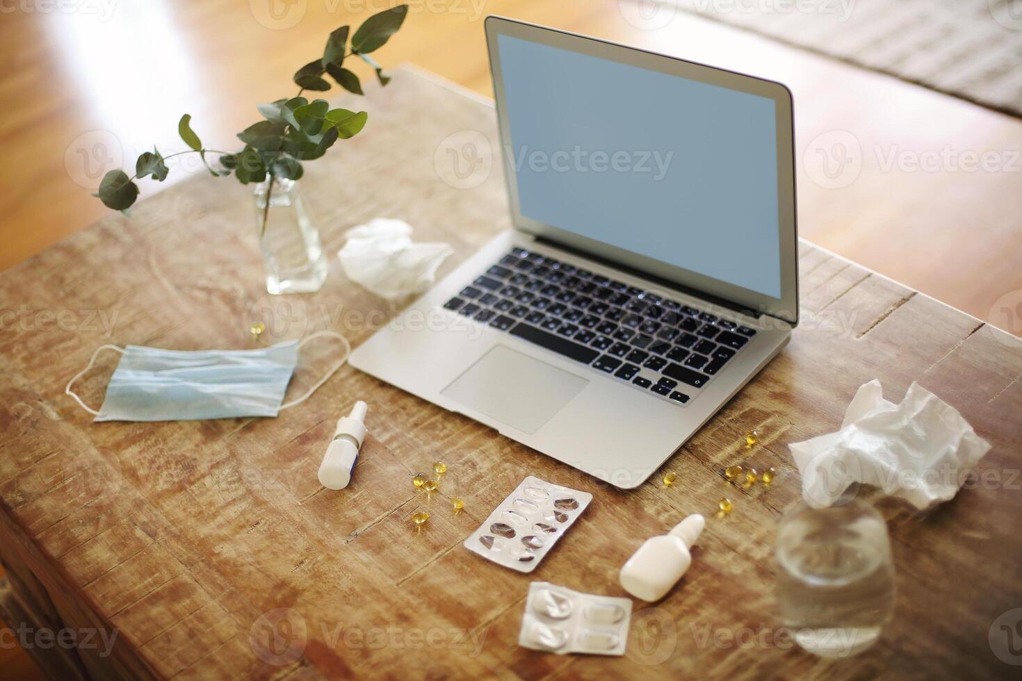 Medications on table near laptop photo