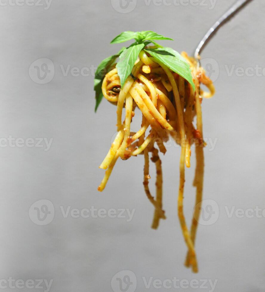 Spaghetti bolognese sauce topping rolled in fork with basil photo