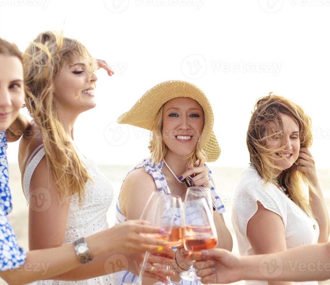 Cheerful women proposing toast on beach photo