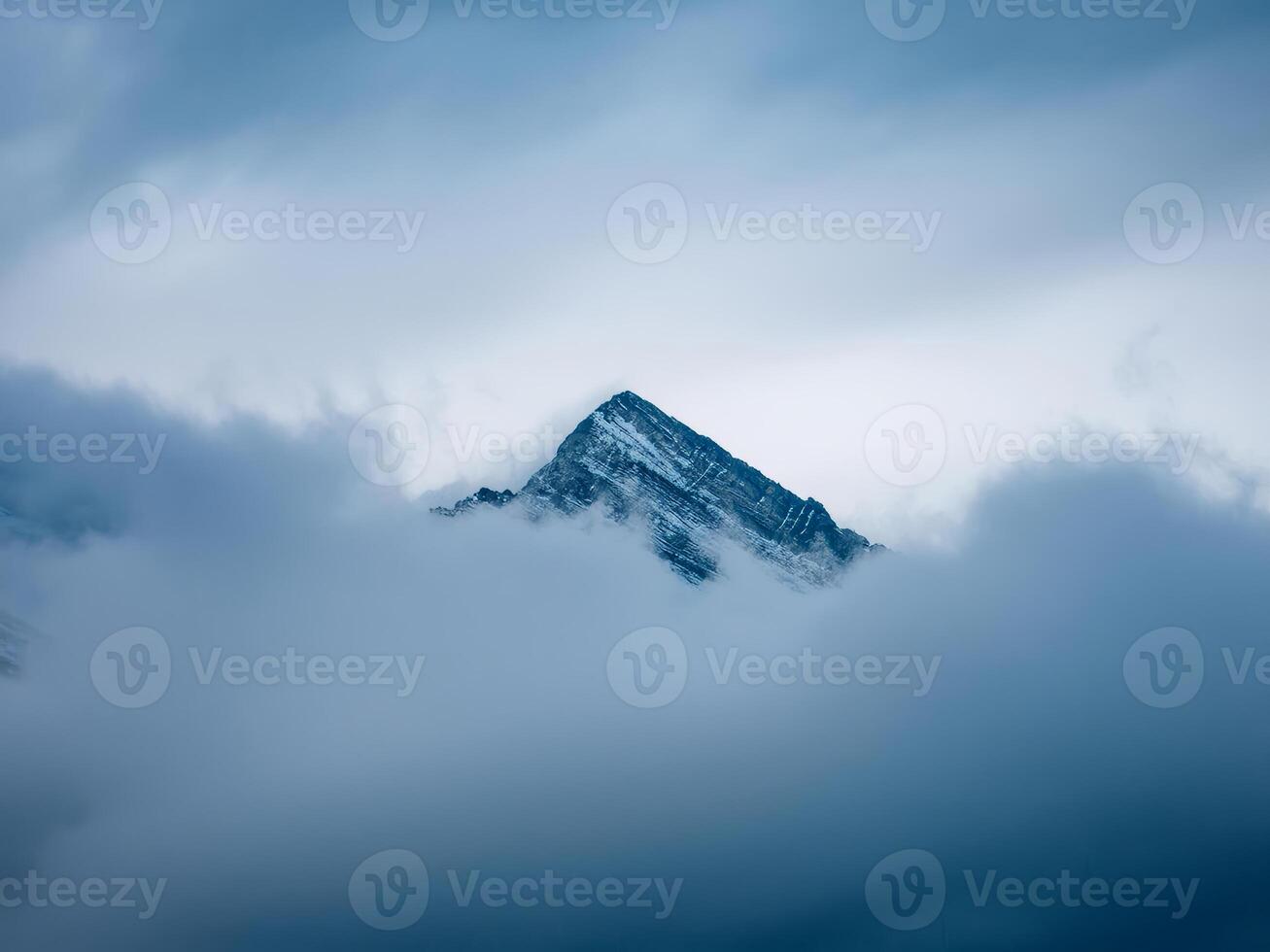 mountain peak looks out of the clouds photo