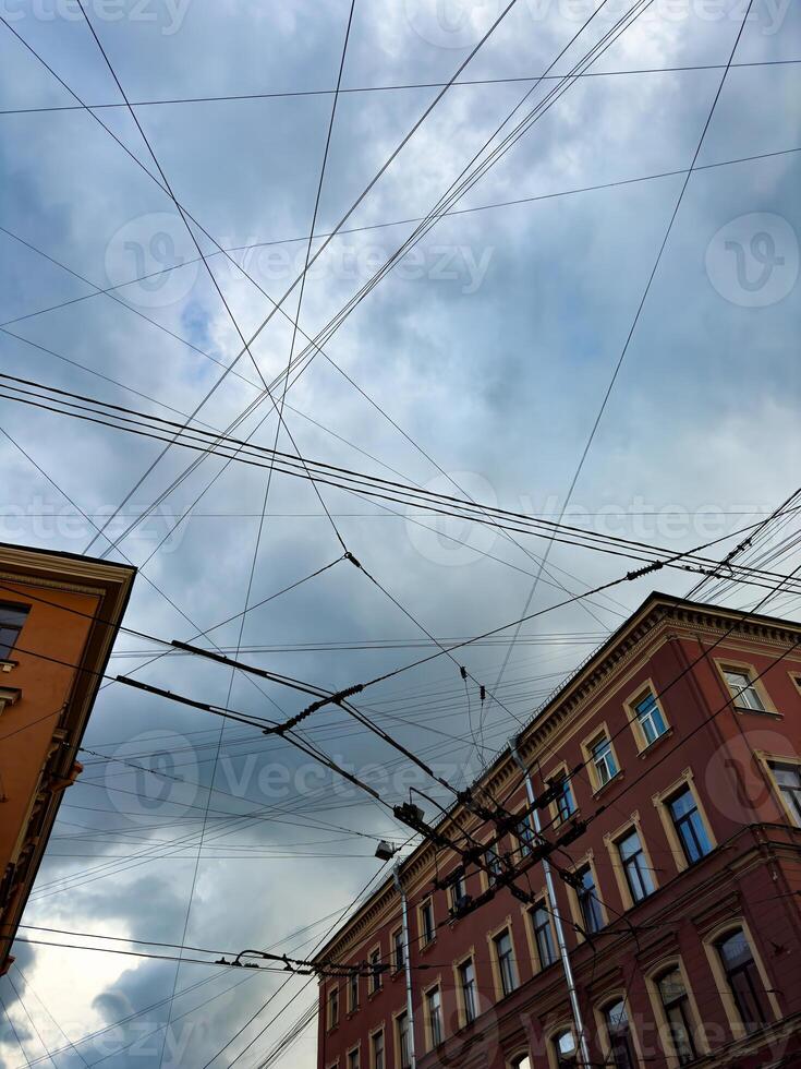 Complex Overhead Tram Wires Against a Cloudy Sky in Saint Petersburg photo