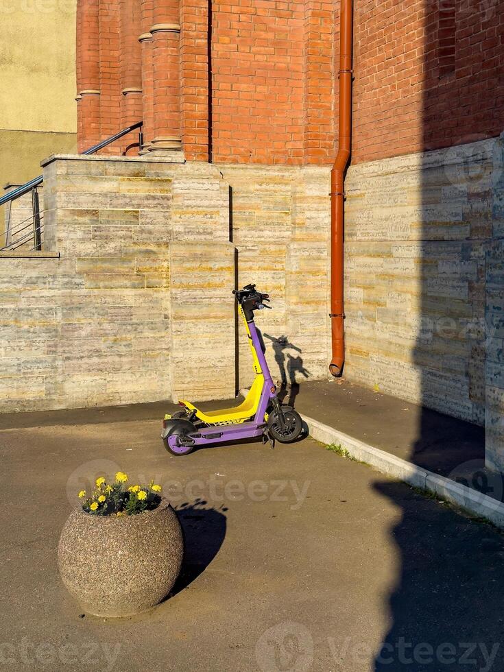 Electric Scooter and Flower Pot in Urban Setting photo