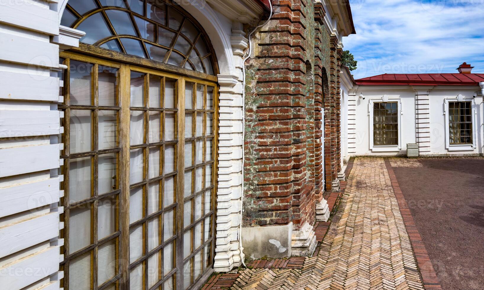 Close-up of a historic building's exterior showcasing a blend of brick and wood elements with intricate window designs, highlighting the architectural details and weathered textures photo