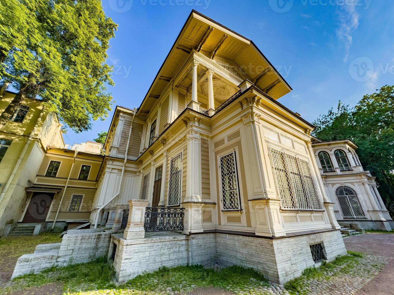 A beautifully preserved historic mansion in St. Petersburg, showcasing intricate architectural details and set against a backdrop of lush greenery. Perfect for themes of heritage, architecture, and cultural history photo