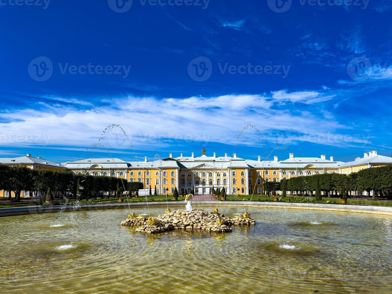 A stunning view of a majestic palace with an elegant fountain in the foreground and a clear blue sky, showcasing the grandeur and beauty of historic architecture on a sunny day photo