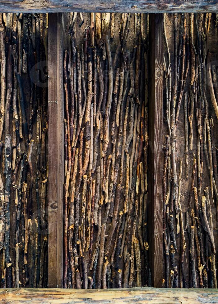 A detailed close-up of a wooden wall constructed from stacked branches, showcasing the rich textures and natural patterns. Perfect for rustic, nature, and architecture-themed projects photo